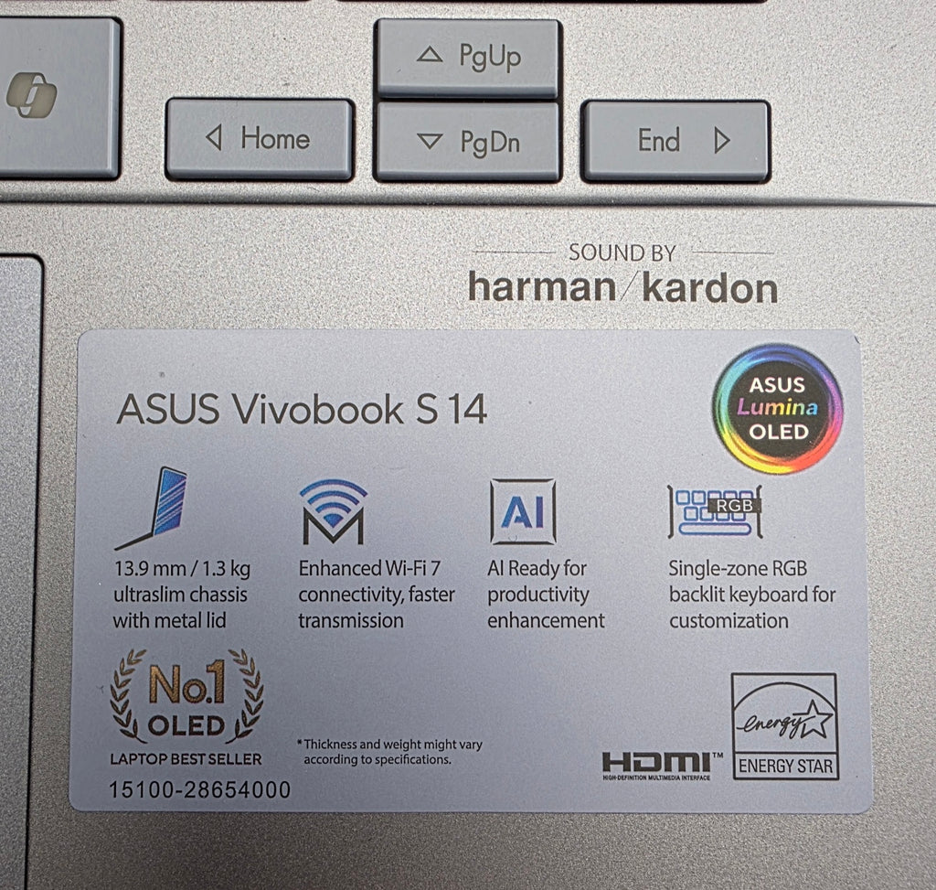 Close-up of a laptop label on an ASUS Vivobook S14 with Harman Kardon branding.