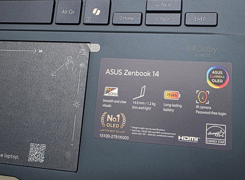 Laptop with ASUS Zenbook 14 branding and specifications on a black surface