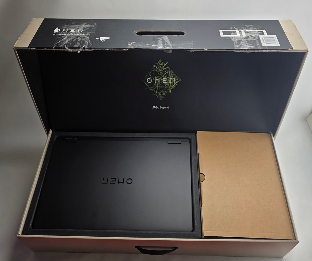 Black laptop in an open box with 'OMEN' branding on a gray background