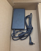 Black power adapter with cable inside a cardboard box